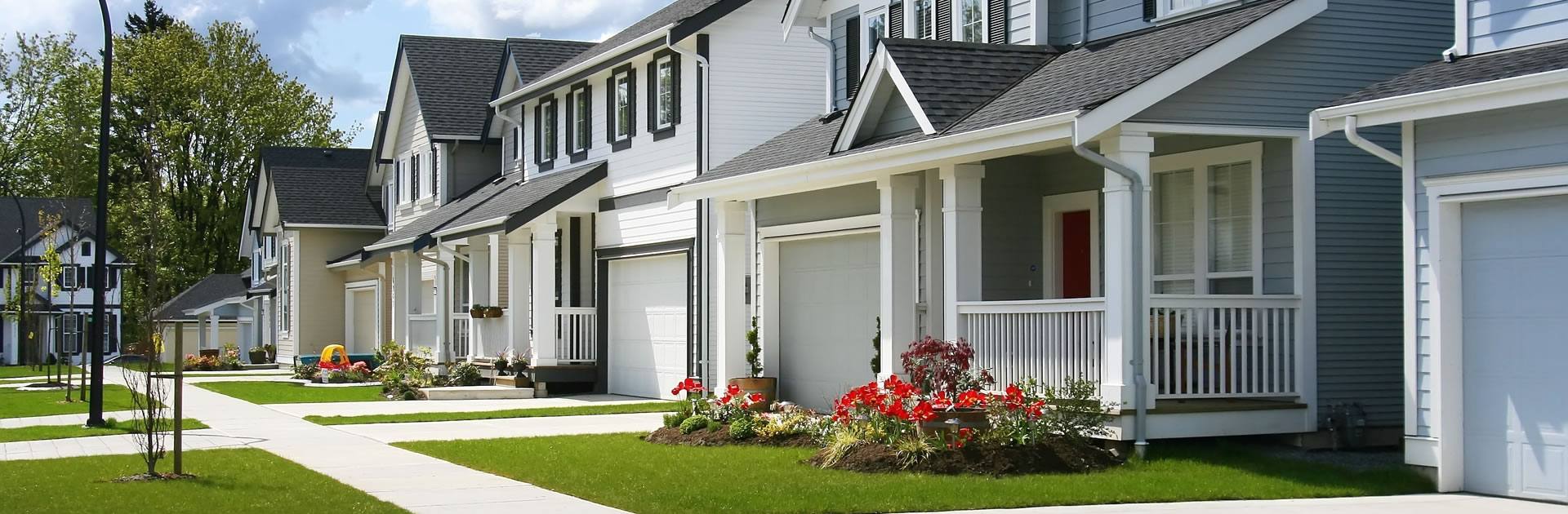 A street of townhomes with front porches and green lawns